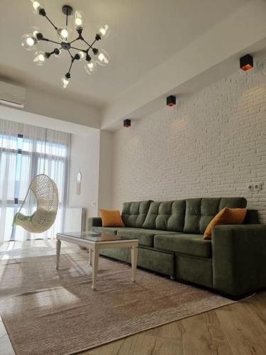 a living room with a green couch and a table at Morkinali Apartment in Tbilisi City