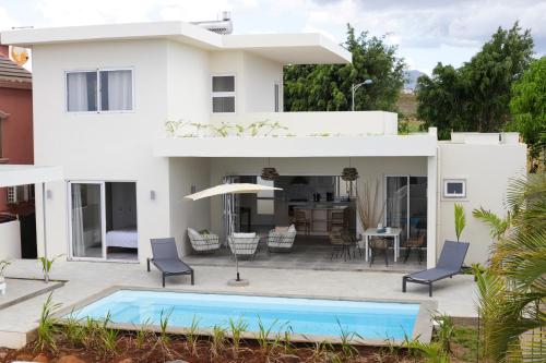 a white house with a swimming pool in front of it at ELOMY VILLA in Albion