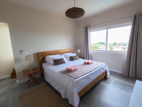 - une chambre dotée d'un lit avec des oreillers roses dans l'établissement ELOMY VILLA, à Albion