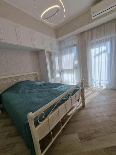 a bedroom with a bed in a room with windows at Morkinali Apartment in Tbilisi City