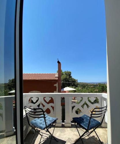 two chairs sitting on the balcony of a house at Yioklima - Renovated Neoclassical House with two bedrooms in Vamos