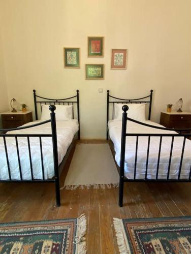 two beds in a room with two rugs at Yioklima - Renovated Neoclassical House with two bedrooms in Vamos