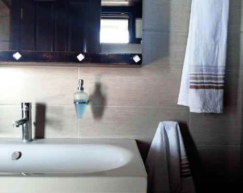 bagno con lavandino bianco e specchio di Spacious rustic country house with sea view a Marónia