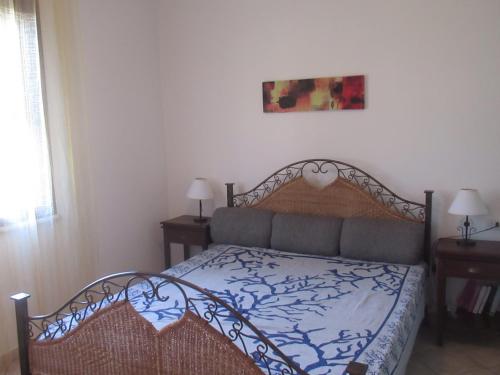 een slaapkamer met een bed en twee lampen en een schilderij bij Casa Alice in Budoni