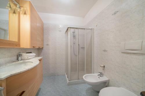 a bathroom with a shower and a toilet and a sink at Appartement Laurin in Merano