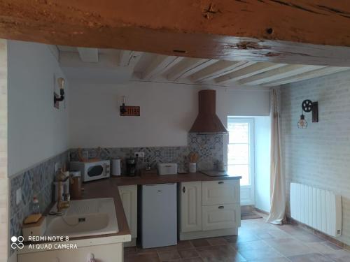 a kitchen with a sink and a stove top oven at O’Pontpoint d’Autrefois 
