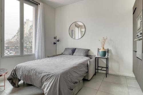 une chambre blanche avec un lit et un miroir dans l'établissement Centric nice apartment 2 steps Le Marais -Republic, à Paris