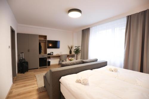 Dubno Eat & Sleep في Nová Dubnica: غرفة معيشة مع سرير وأريكة