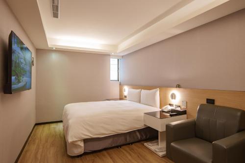 a hotel room with a bed and a chair at HUB HOTEL Tucheng in Tucheng
