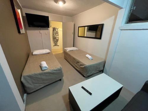 紐卡索的住宿－梅菲爾德汽車旅館，小房间设有两张床和一张桌子