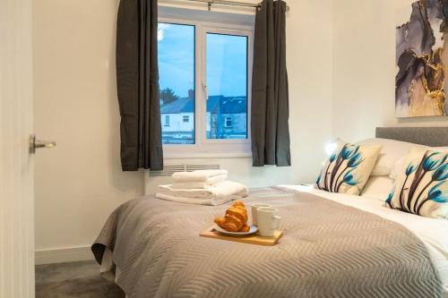 een slaapkamer met een bed met een dienblad met eten erop bij The Mews, Amazing Newport 2 BR, Excellent location, Parking, Perfect for Contractors in Newport