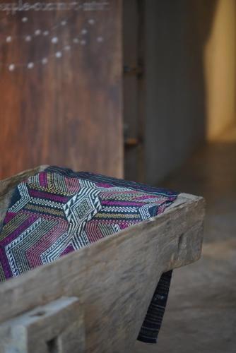 a wooden bench with a colorful cushion on it at Dechiu in Hoi An