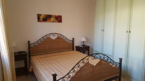 ein Schlafzimmer mit einem Bett mit einem Kopfteil aus Holz in der Unterkunft casa Angy in Budoni