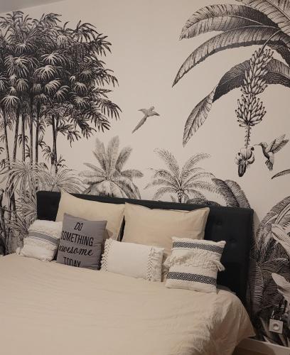 - une chambre avec un lit recouvert de palmiers dans l'établissement Appartement chic 5 min Disneyland/Vallée Village, à Serris