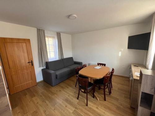 a living room with a table and a couch at Apartments Prekmurska vas - Vital Resort in Moravske Toplice