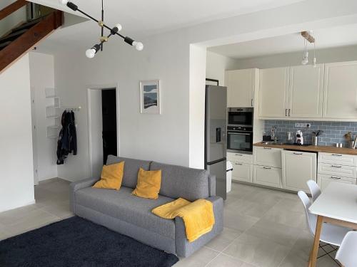 ein Wohnzimmer mit einem Sofa und einer Küche in der Unterkunft Ozark Balatonszemes in Balatonszemes