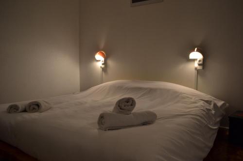 Una cama con dos toallas y dos luces. en Auberge de Jeunesse HI Boulogne-sur-Mer en Boulogne-sur-Mer