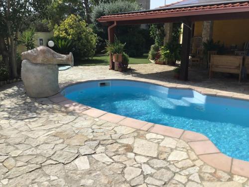 a swimming pool with a statue next to a house at Apartment in Villa, Beach 3 minutes walk, spiaggia 3 minuti a piedi in Su Forti