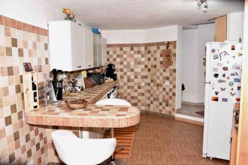 a kitchen with a counter and a refrigerator at Apartment in Villa, Beach 3 minutes walk, spiaggia 3 minuti a piedi in Su Forti