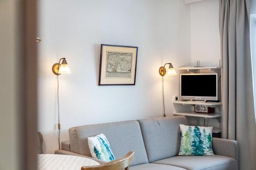 a living room with a couch and a tv at Haus Excelsior Top 22 in Seefeld in Tirol