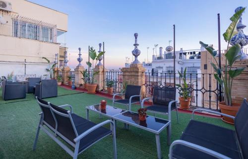 a patio with chairs and a table on a balcony at Sevilla deluxe suites in Seville