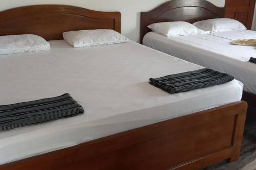帕納吉的住宿－ANGELO'S - 2 HOLIDAY VILLAS IN PANAJI, NORTH GOA，两张带白色床单和毛巾的床