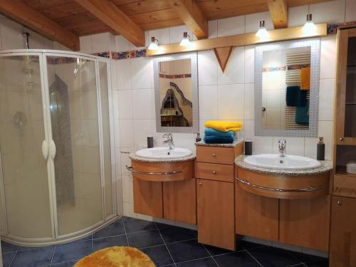 a bathroom with two sinks and a shower at Dachgeschosswohnung am Waldrand in Arzl im Pitztal