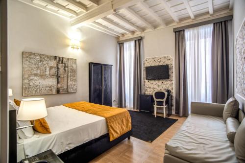 um quarto de hotel com uma cama e um sofá em Relais Fontana Di Trevi Hotel em Roma