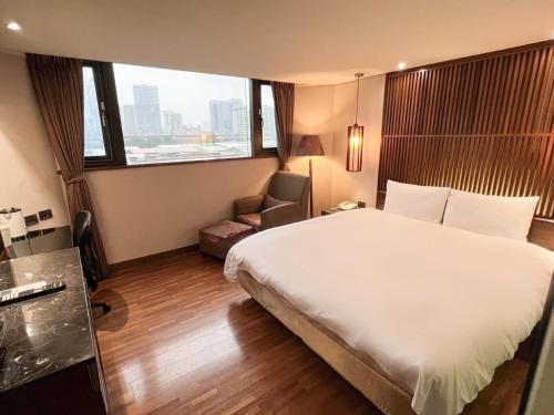台北的住宿－承攜行旅-台北八德館，酒店客房带一张大床和一把椅子