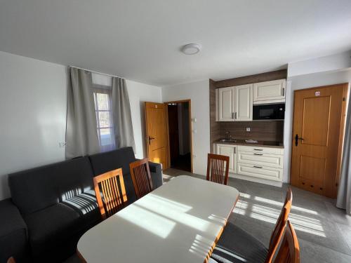 a living room with a black couch and a table at Apartments Prekmurska vas - Vital Resort in Moravske Toplice