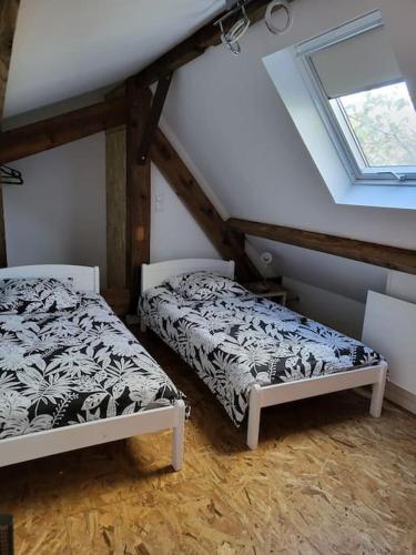 - 2 lits dans une chambre mansardée dans l'établissement Cottage cosy à la campagne, à Queyssac