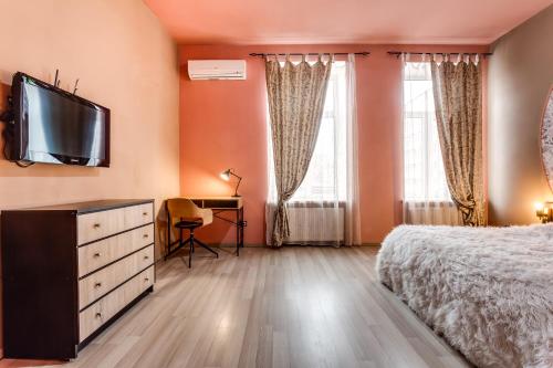 リヴィウにあるПростора квартира в центрі Львоваのベッドルーム1室(ベッド1台、壁掛けテレビ付)