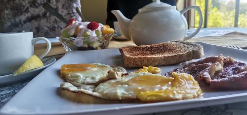 a plate of breakfast food with eggs and toast at Angelmalatji guesthouse in Graskop