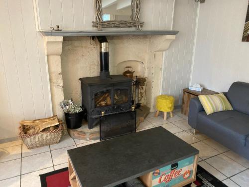 a living room with a stove and a couch at Swift Gites Creuse in Ventenat