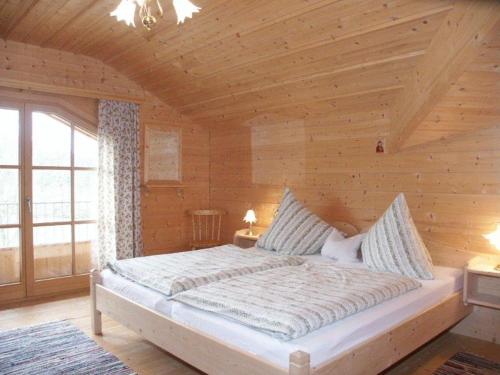 een slaapkamer met een groot bed in een houten kamer bij Braunhof in Bad Feilnbach