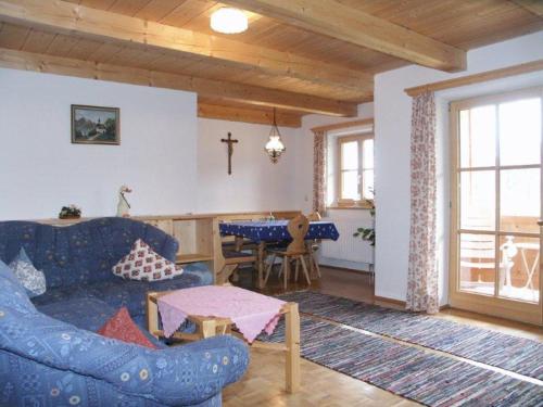 a living room with a blue couch and a table at Braunhof in Bad Feilnbach