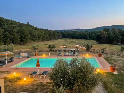 una gran piscina con sombrillas en una colina en Villa Borgo Pian di Sala en San Gimignano