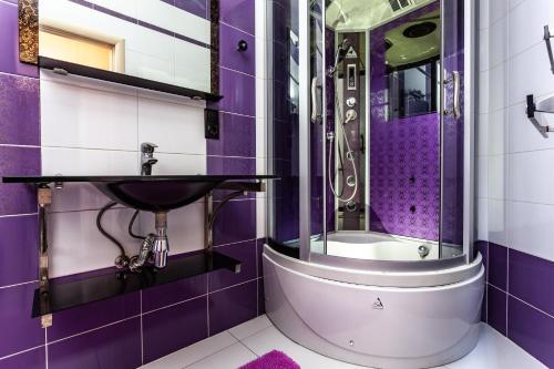 リヴィウにあるПростора квартира в центрі Львоваの紫色のバスルーム(シンク、シャワー付)