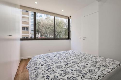 Apartamento Magnifico em Oeiras في باكو دي أركوس: غرفة نوم بيضاء بها سرير ونافذة