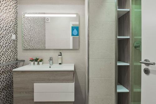 un bagno con lavandino e specchio di Apartamento Magnifico em Oeiras a Paço de Arcos