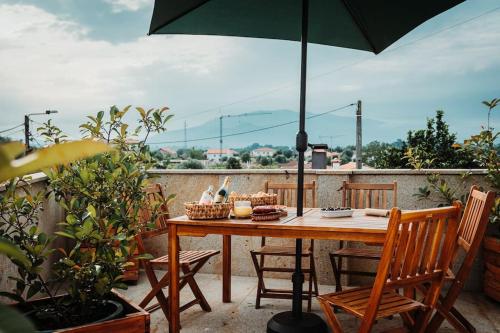 una mesa en un balcón con sombrilla en Villa Henriques, en Ponte de Lima