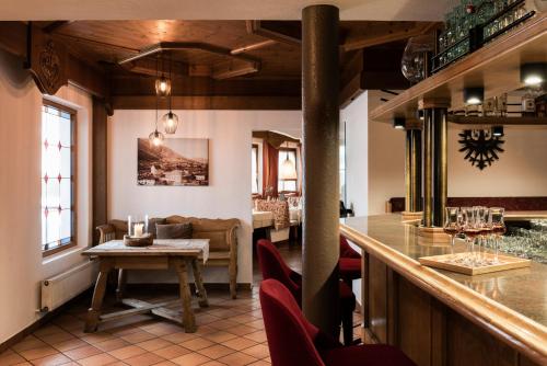 een bar in een restaurant met een tafel en stoelen bij Hotel Medrazerhof in Fulpmes