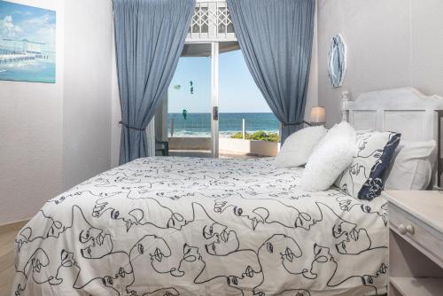 a bedroom with a bed with a view of the ocean at LA CRETE SANDS NO 7 in Uvongo Beach