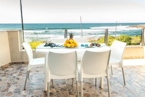 a table with a bowl of fruit on it with the beach at LA CRETE SANDS NO 7 in Uvongo Beach