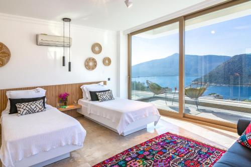 a bedroom with two beds and a large window at Villa Moonshine Fantastic View Large Privat Pool in Kalkan