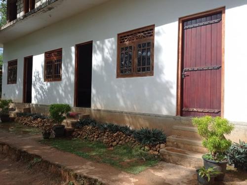 uma casa branca com uma porta vermelha e algumas plantas em Green berg 