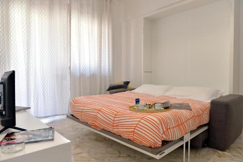 a bedroom with a bed with a desk and a tv at Tizi Apartments Corso Reginna in Maiori