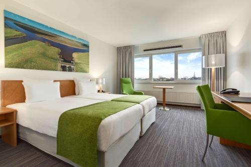 een hotelkamer met een bed en een bureau bij NH Groningen Hotel in Groningen