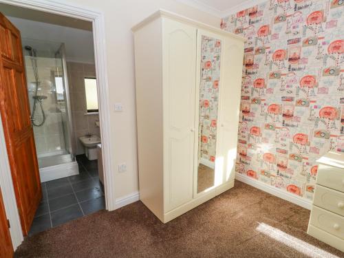 a bathroom with a walk in shower and a toilet at Cherry Tree House in Penzance