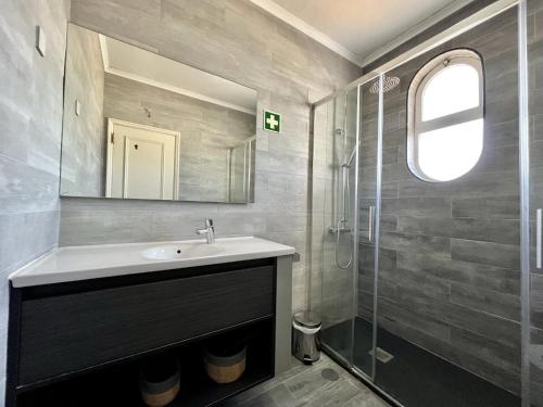 a bathroom with a sink and a glass shower at Albufeira Delight with Pool by Homing in Guia